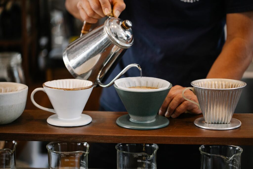 Faceless barista pouring water in dripper